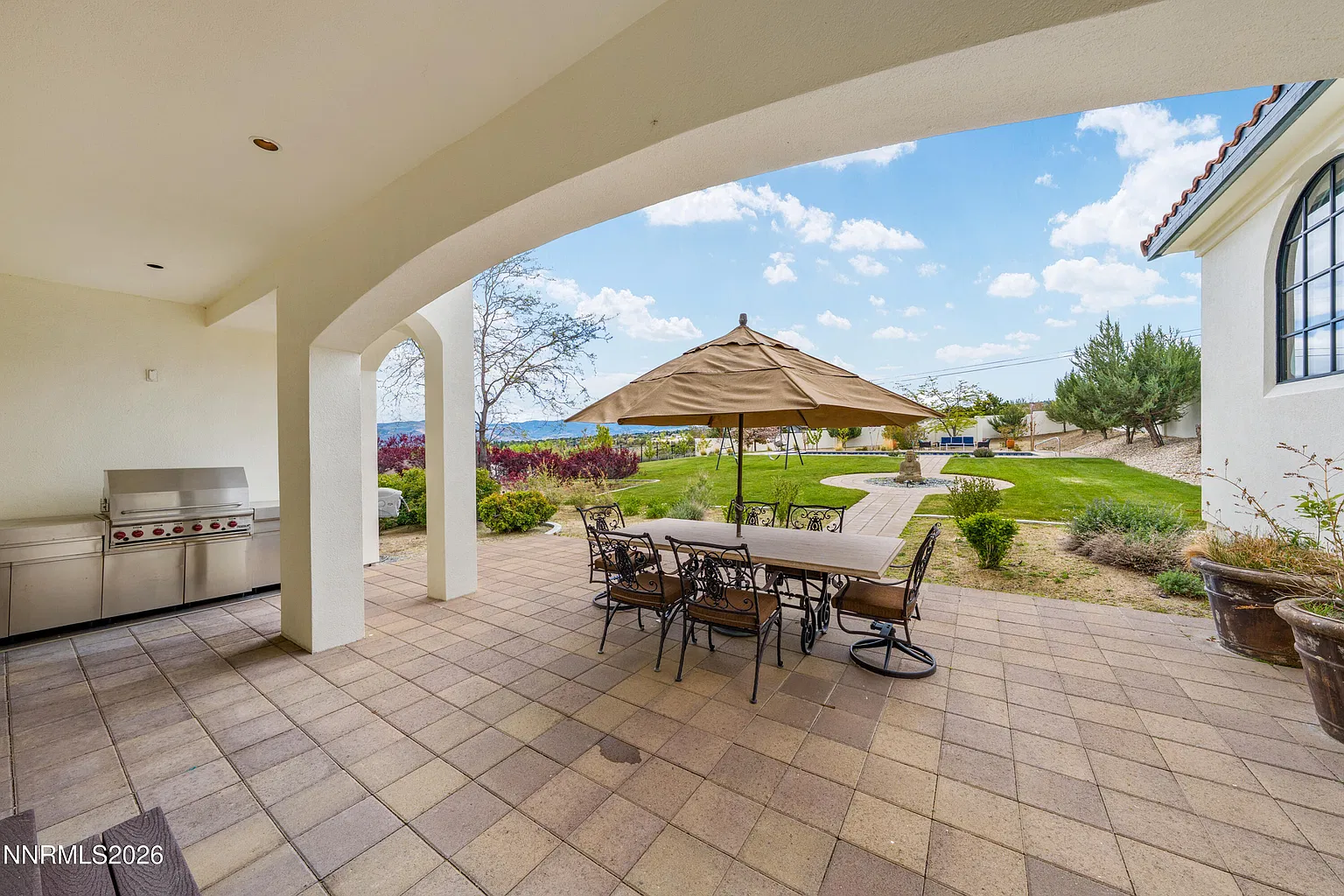 Covered patio with an outdoor kitchen and dining table