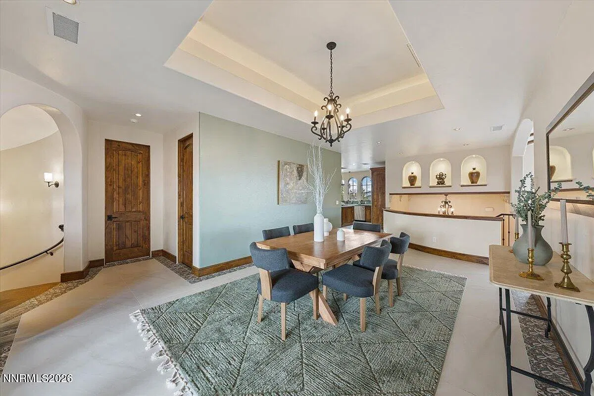 Dining room with a sage accent wall and chandelier