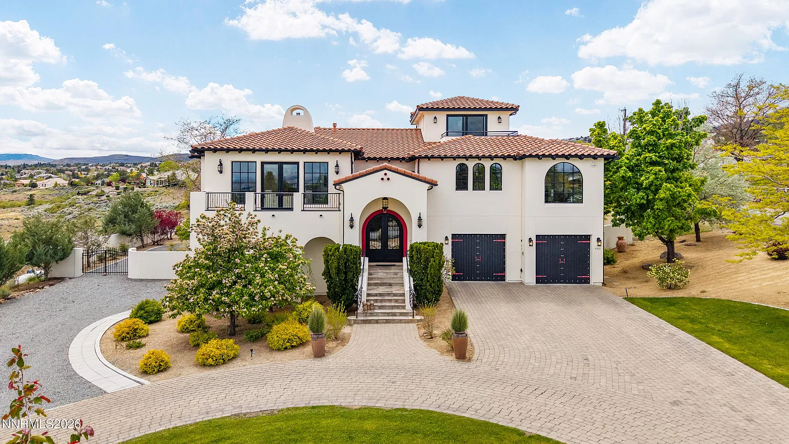 Front of the house with the arched entry and loop drive