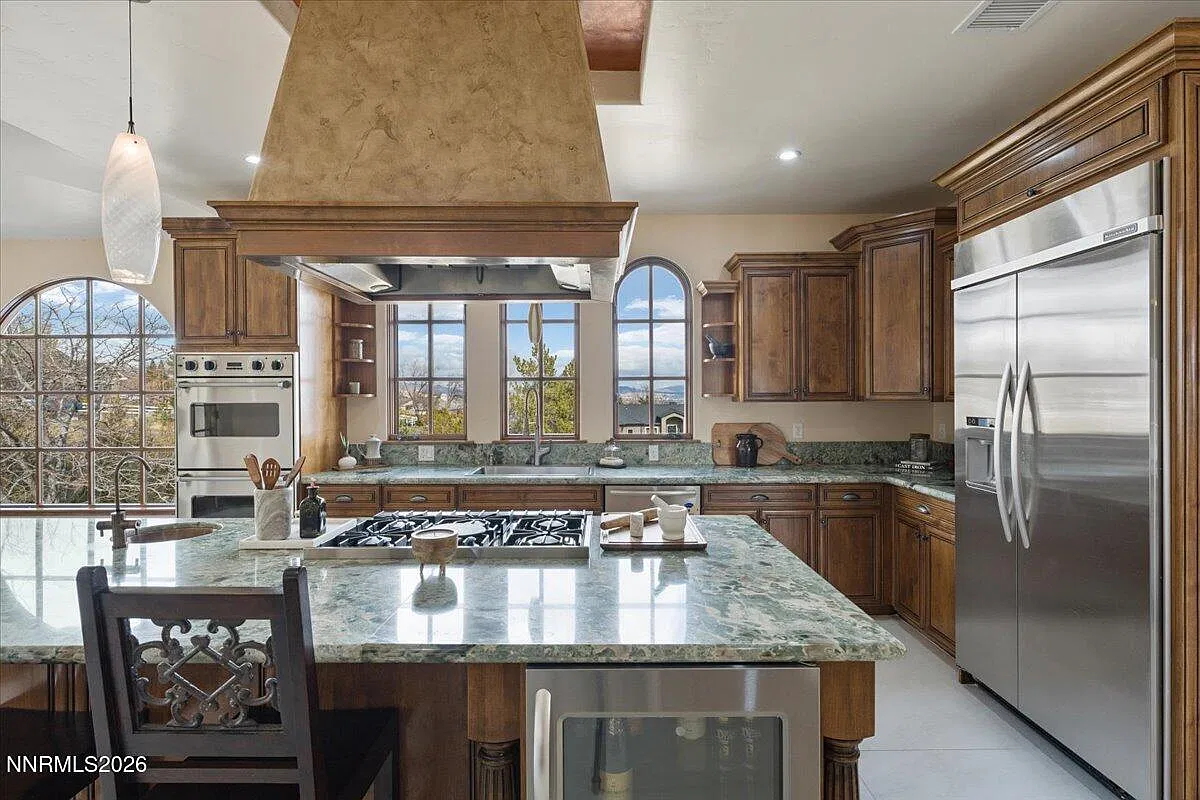 Kitchen with green granite island, bar seating and range hood